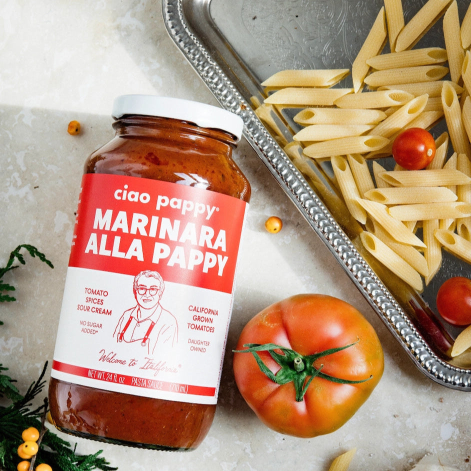 marinara sauce bottle sitting on counter surrounded by pasta 