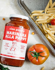 marinara sauce bottle sitting on counter surrounded by pasta 