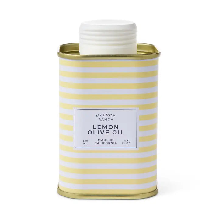 A metal tin of McEvoy Ranch Lemon Olive Oil with a white screw cap, featuring a white label with black text and a yellow and white horizontal stripe pattern, set against a plain white background.