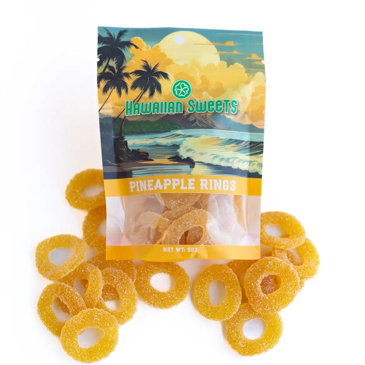 A bag of Hawaiian Sweets Pineapple Rings candy with several loose yellow-orange ring-shaped gummy candies scattered in front on a white background.