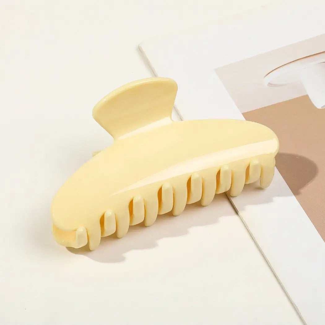 Yellow hair claw clip on a light surface