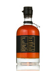 A bottle of Laurel & Ash Farm Maple Syrup, Grade A, Amber flavor, in a clear glass bottle with amber liquid, a black label with gold text, and a black screw cap, shown on a white background with a reflection.
