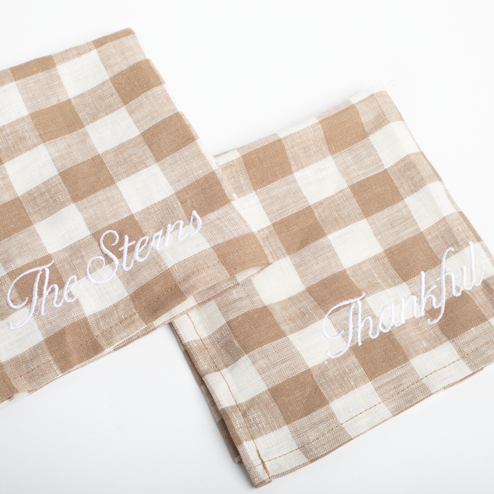 Two checkered towels with embroidered text on a white background