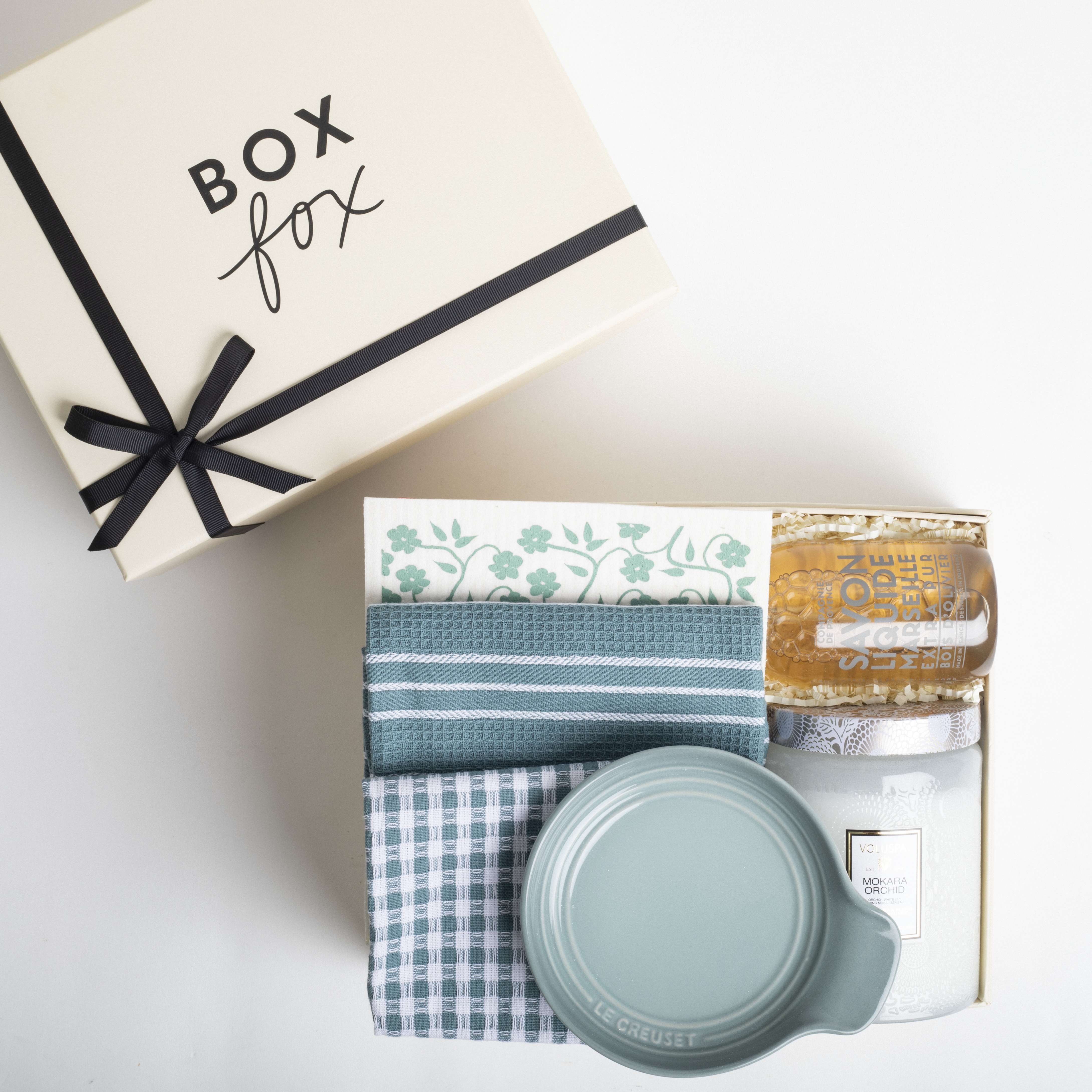Gift set with a box, towels, and a jar on a white background
