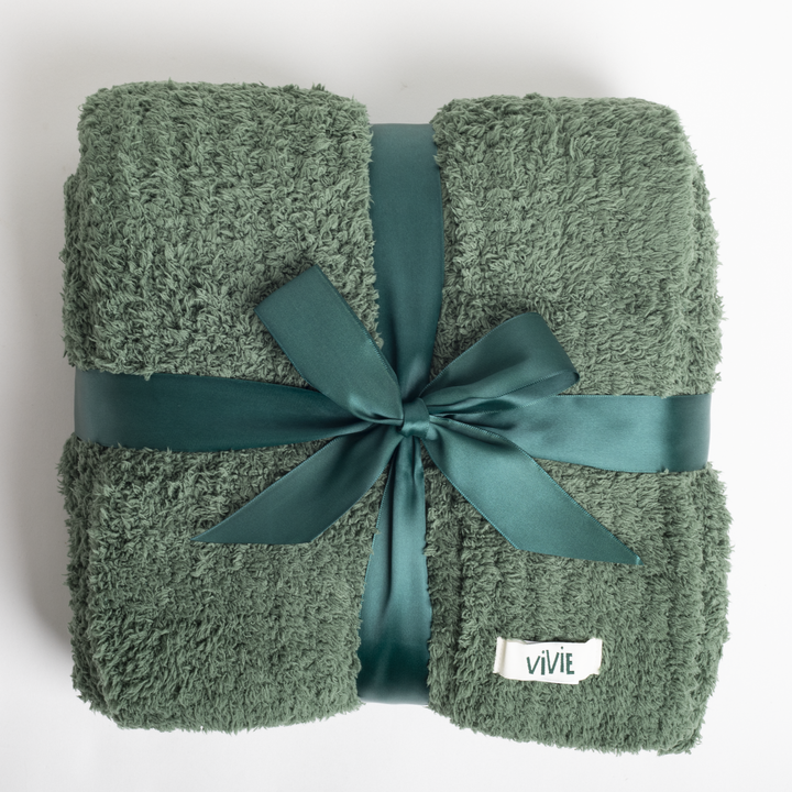 Green textured blanket with a satin ribbon and 'VIVIE' label on a white background