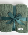 Green textured blanket with a satin ribbon and 'VIVIE' label on a white background