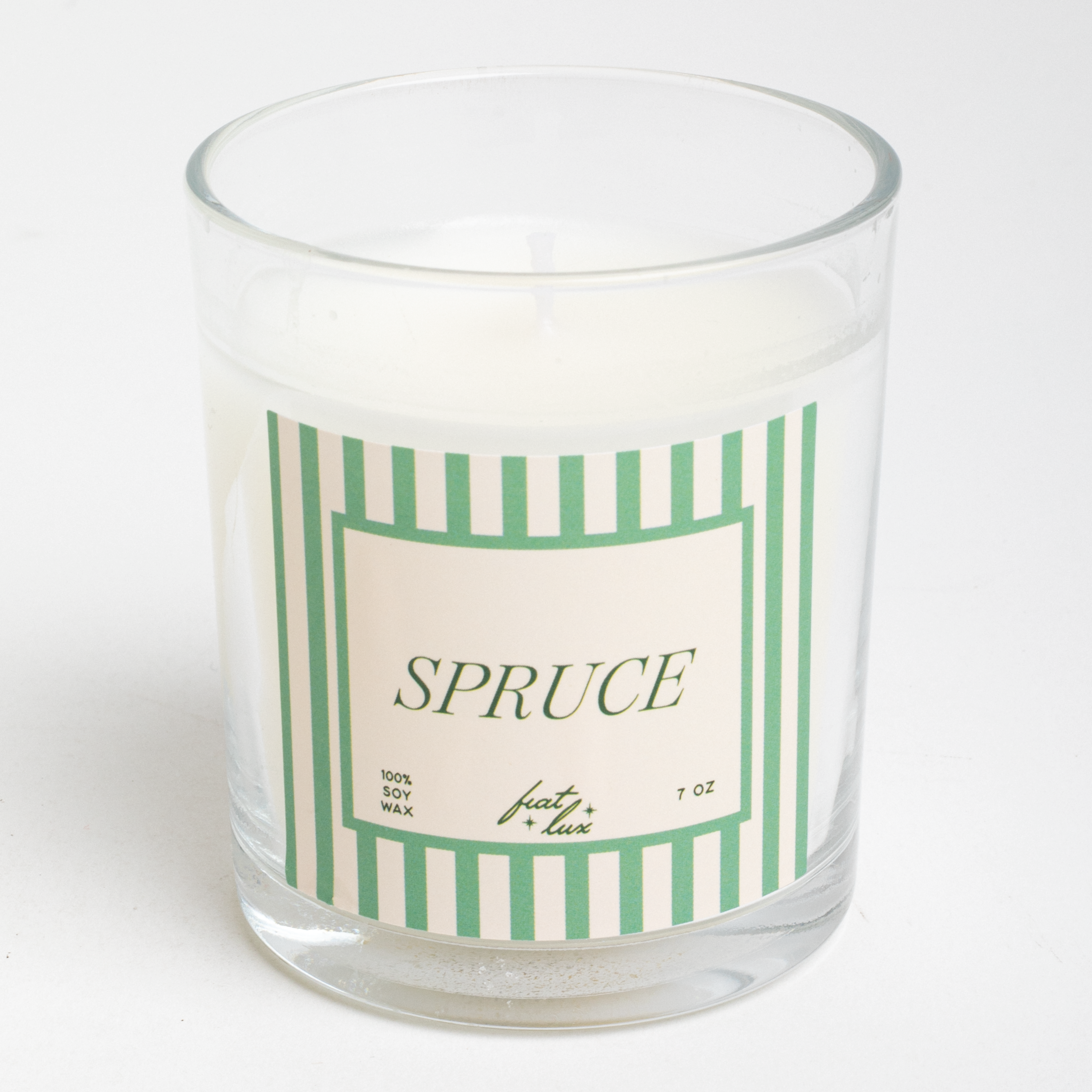 Glass candle with a green and white striped label on a white background
