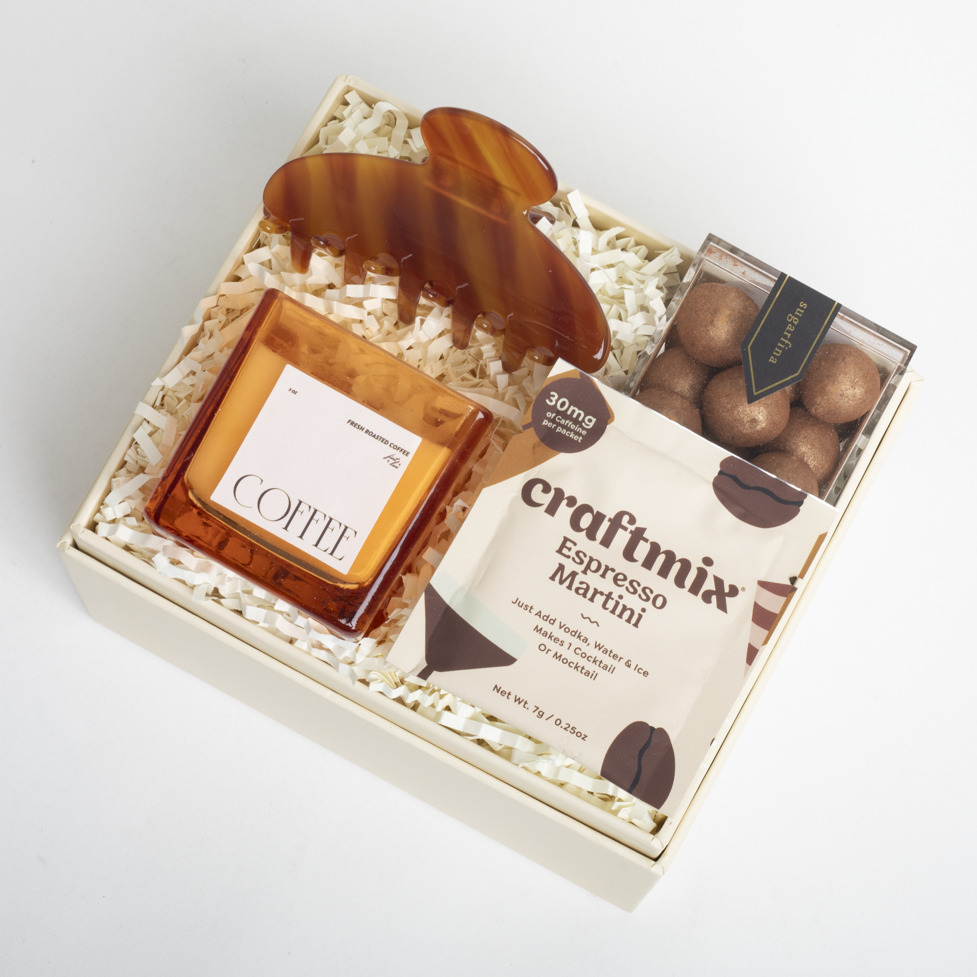 Gift set with coffee, espresso martini mix, and truffles in a box on a white background