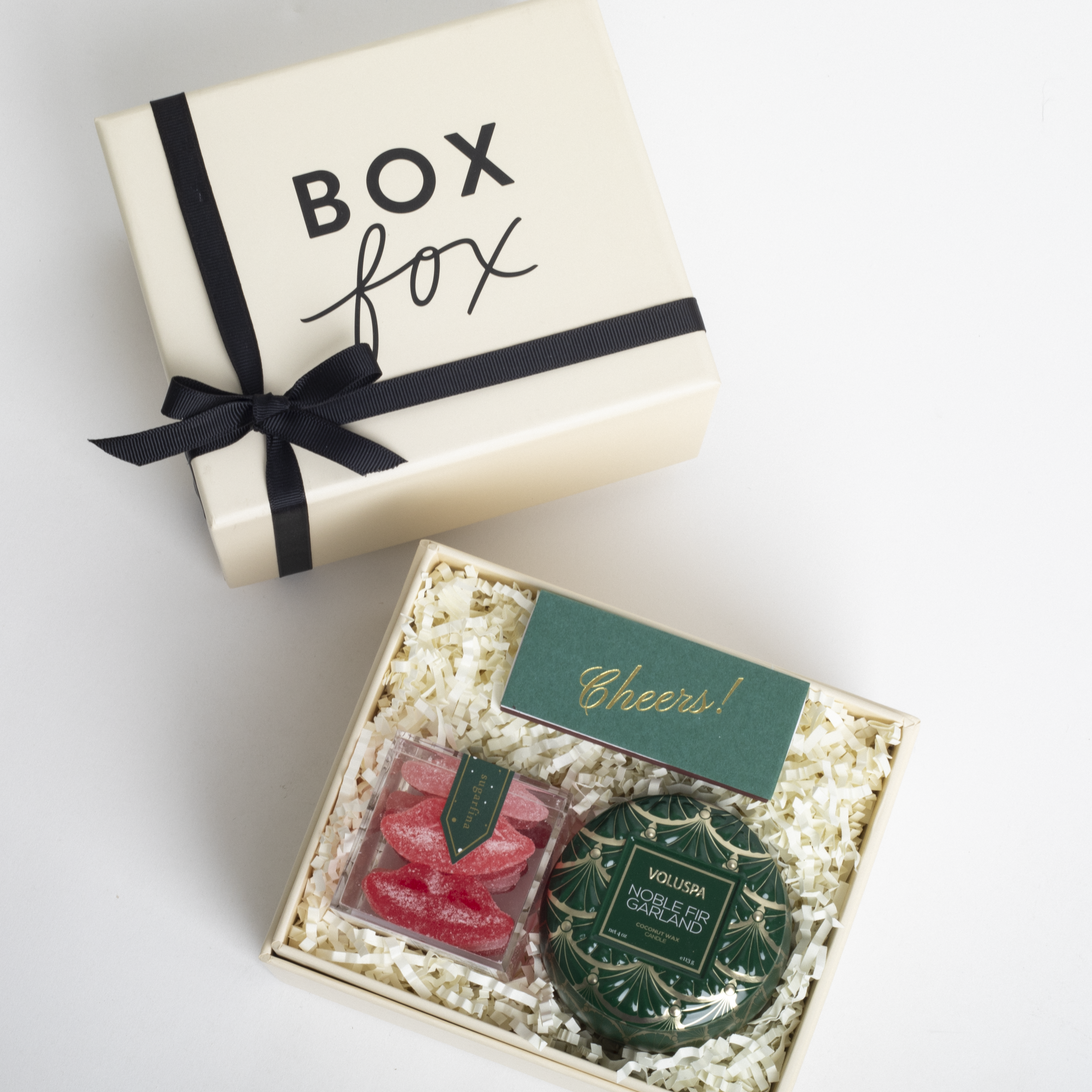 Gift box with 'Box Fox' branding, black ribbon, and a small green card inside.