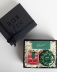 Gift box with 'Box Fox' branding, containing a red item and a green decorative item on a white background.