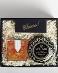 Gift set with Voluspa candle and other items in a black box on a light gray background