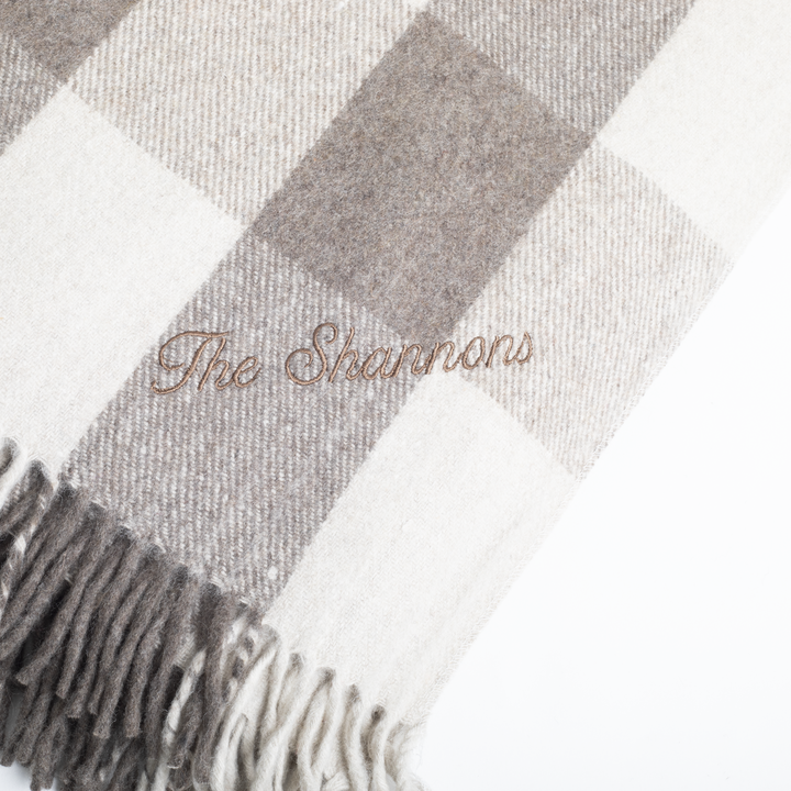 Checkered blanket with 'The Shannons' embroidery on a white background