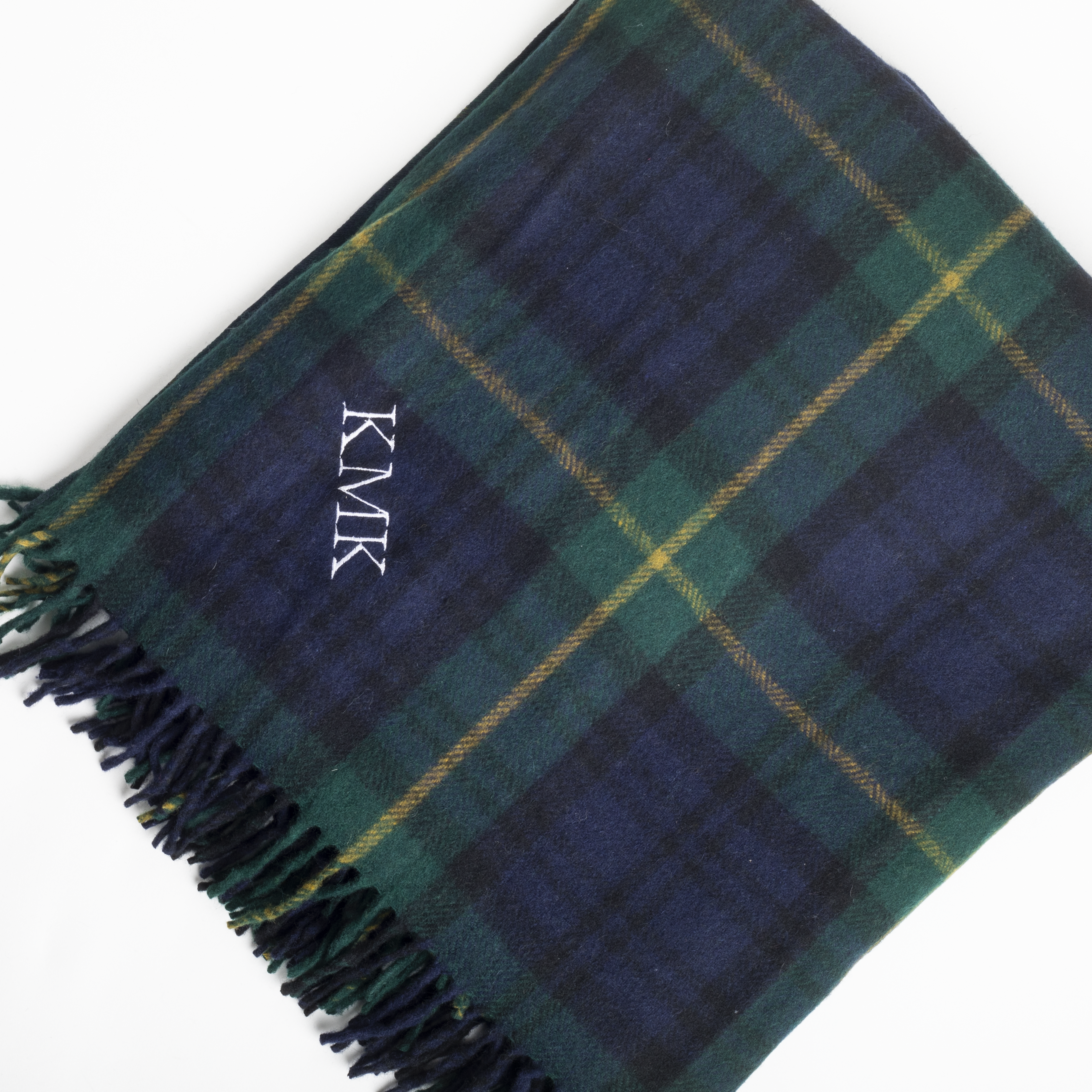 Plaid blanket with 'KMK' monogram on a white background