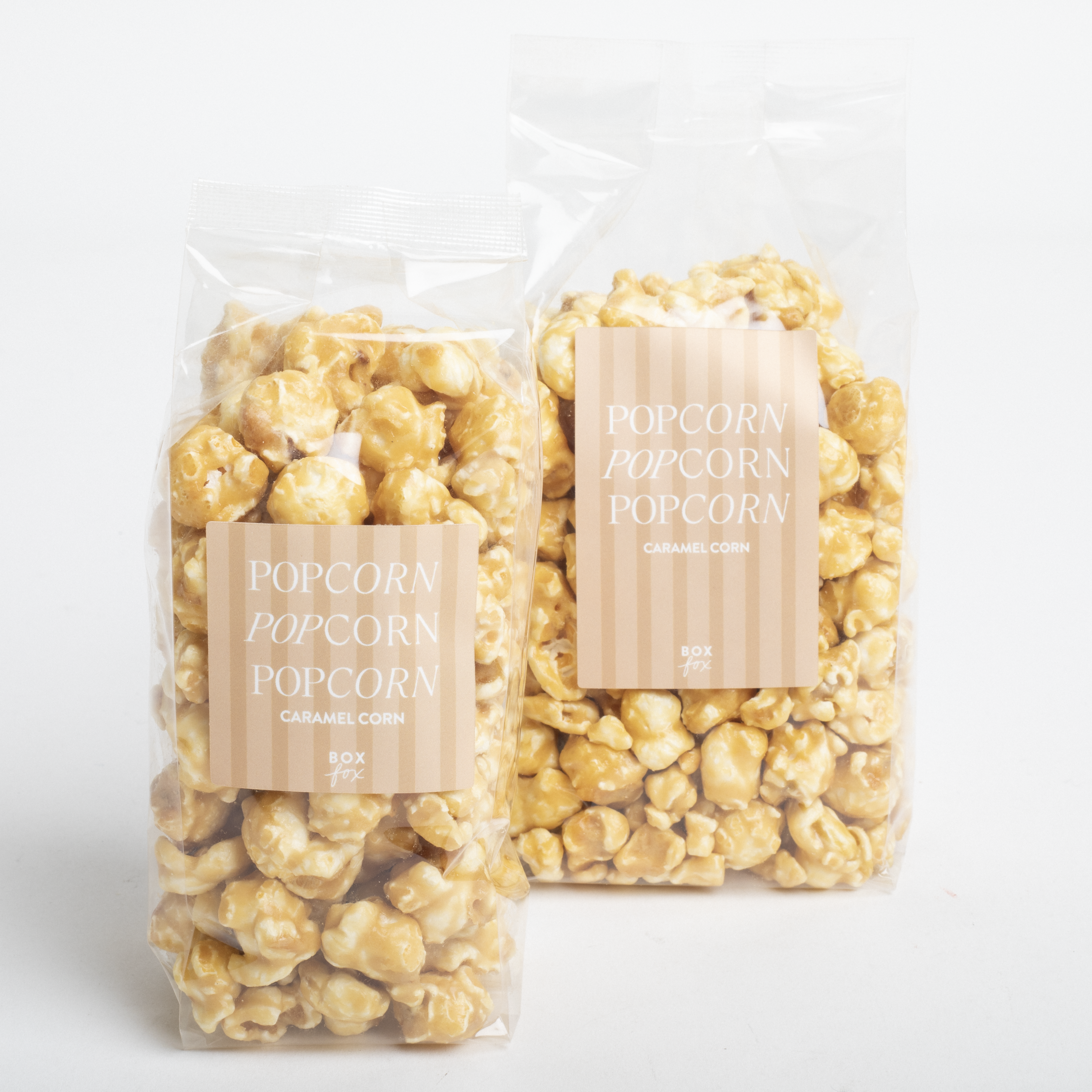Two packages of caramel popcorn with visible labels on a white background