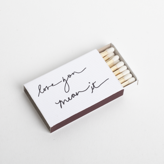 Matchbox with 'love you mean it' text on a white background
