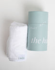 Skincare product and towel on a light gray background