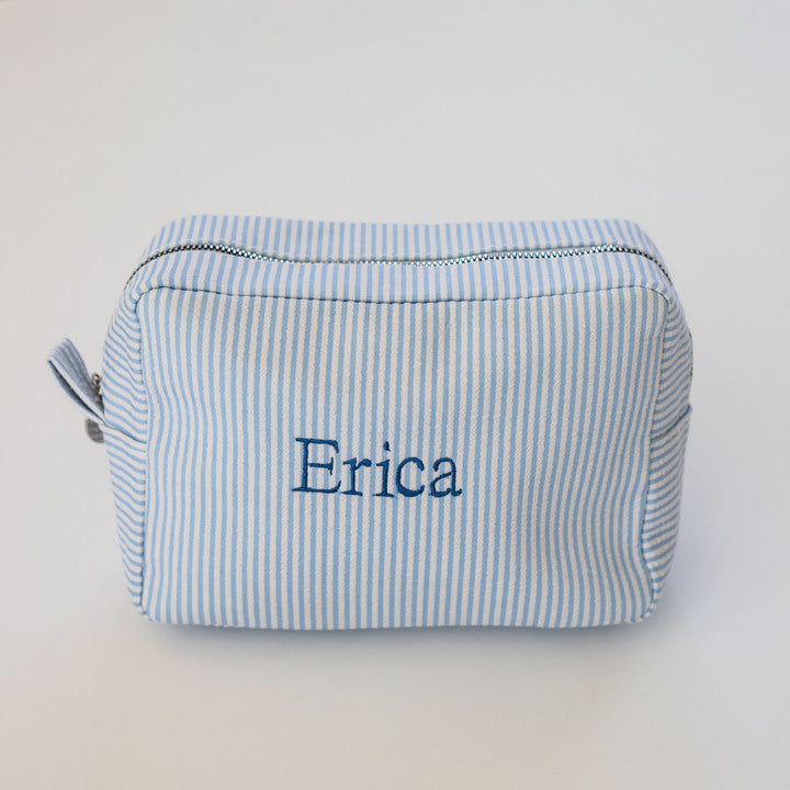 blue embroidered makeup bag on a white background