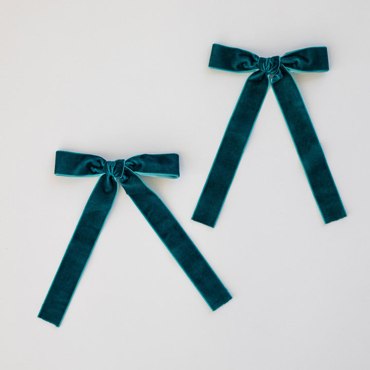 two teal bows on a white background