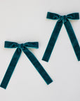 two teal bows on a white background