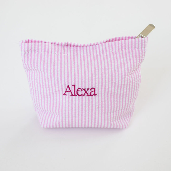 Pink striped pouch with 'Alexa' embroidered on a white background