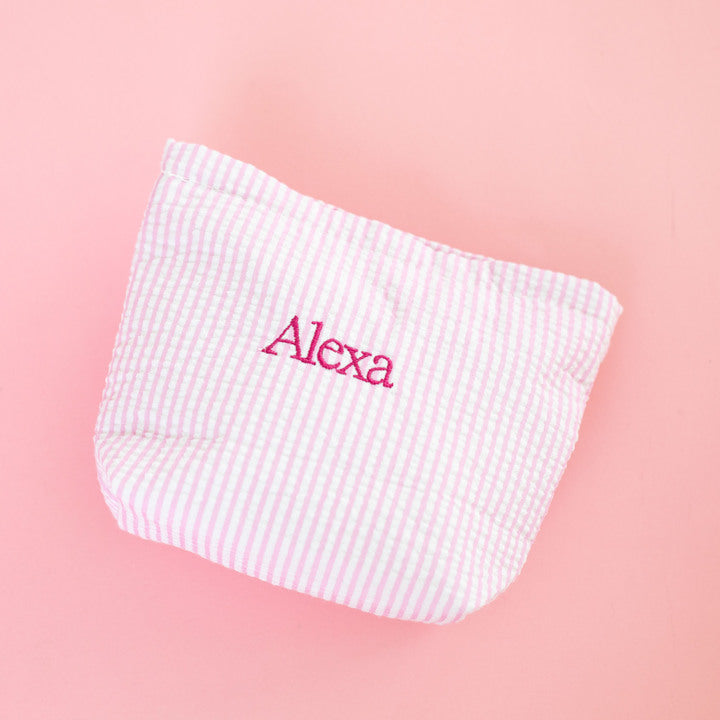 Pink and white checkered pouch with 'Alexa' embroidery on a pink background