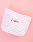 Pink and white checkered pouch with 'Alexa' embroidery on a pink background