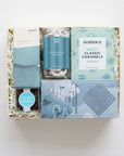 Gift box with various products including chocolates and caramels on a white background