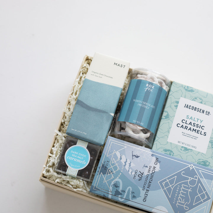 Gift box with assorted snacks and treats on a white background