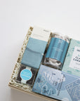 Gift box with assorted snacks and treats on a white background