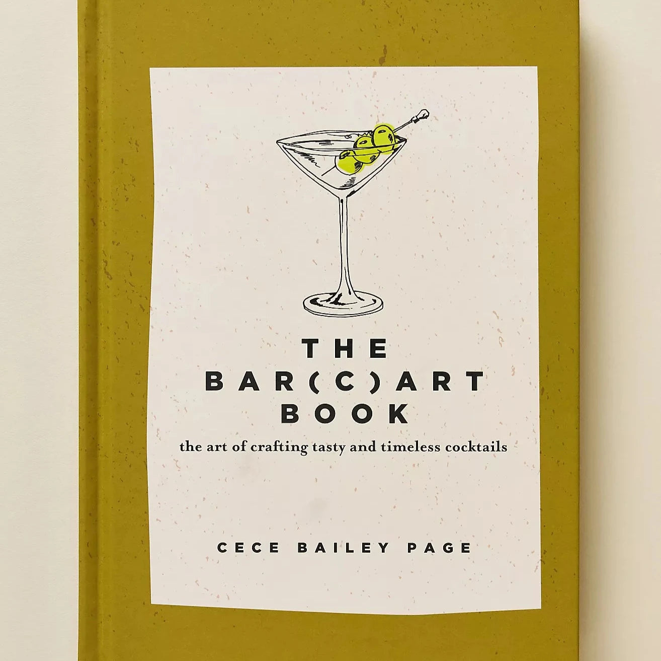 olive colored book cover for the bar (c)art book with an image of a martini on it