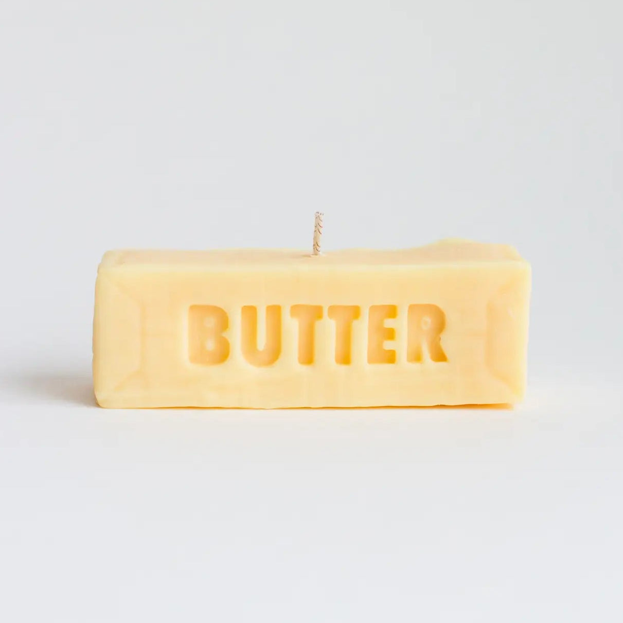 Rectangular candle with 'BUTTER' text on a light gray background