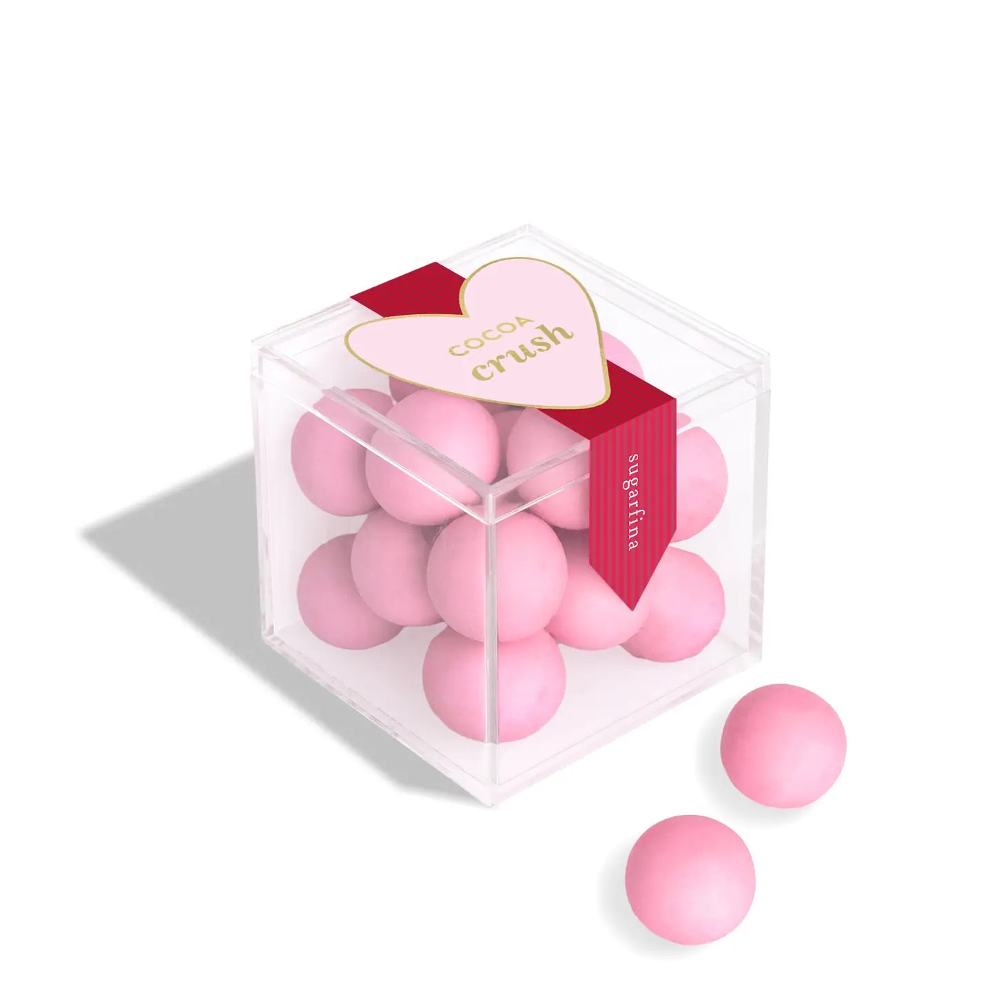 Pink candies in a clear cube with a red and white label on a white background