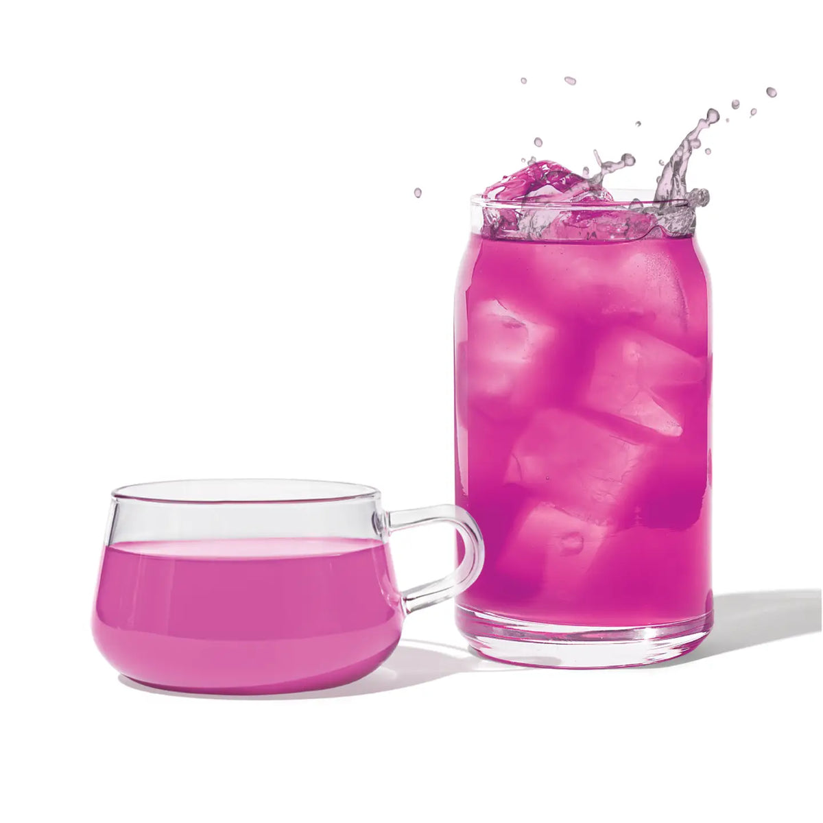 Pink drink with ice cubes in a glass and a mug on a white background