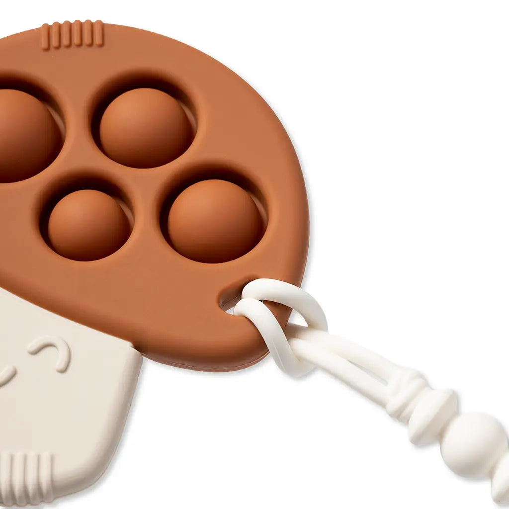 Brown silicone mold with white handle on a white background
