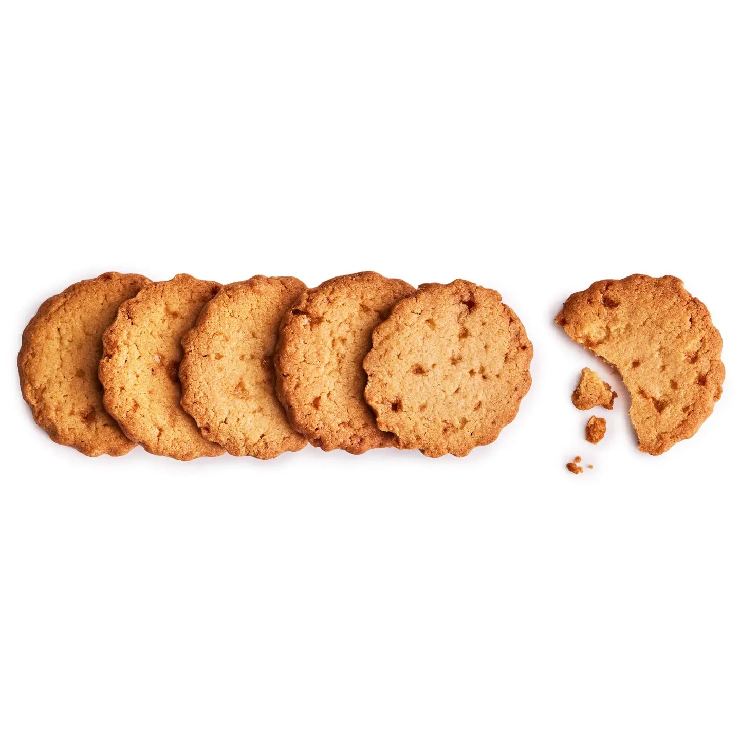 Row of whole cookies with one broken cookie on a white background