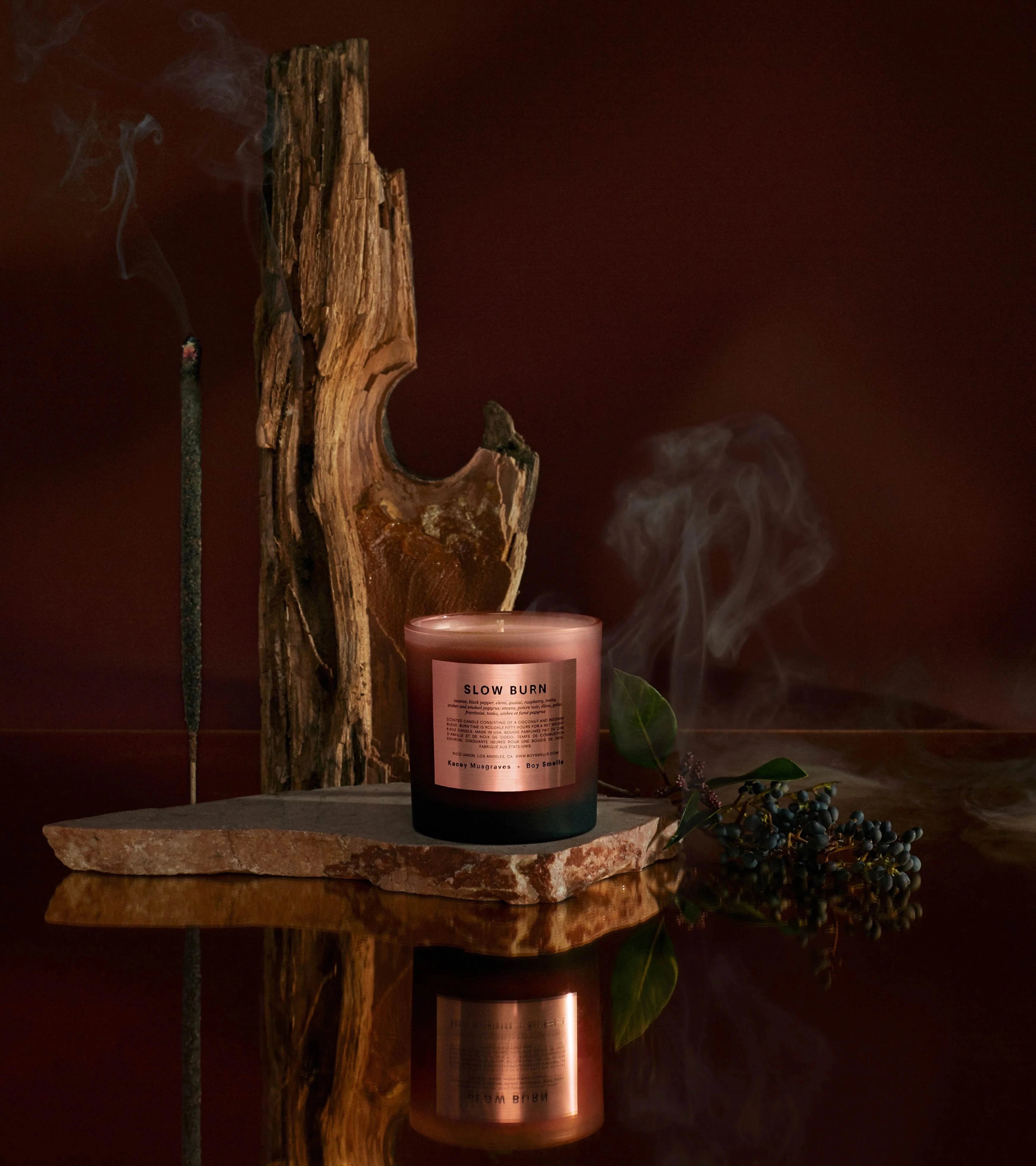 matte gradient glass tumbler with metallic "rose gold" label sitting on piece of wood with incense around it