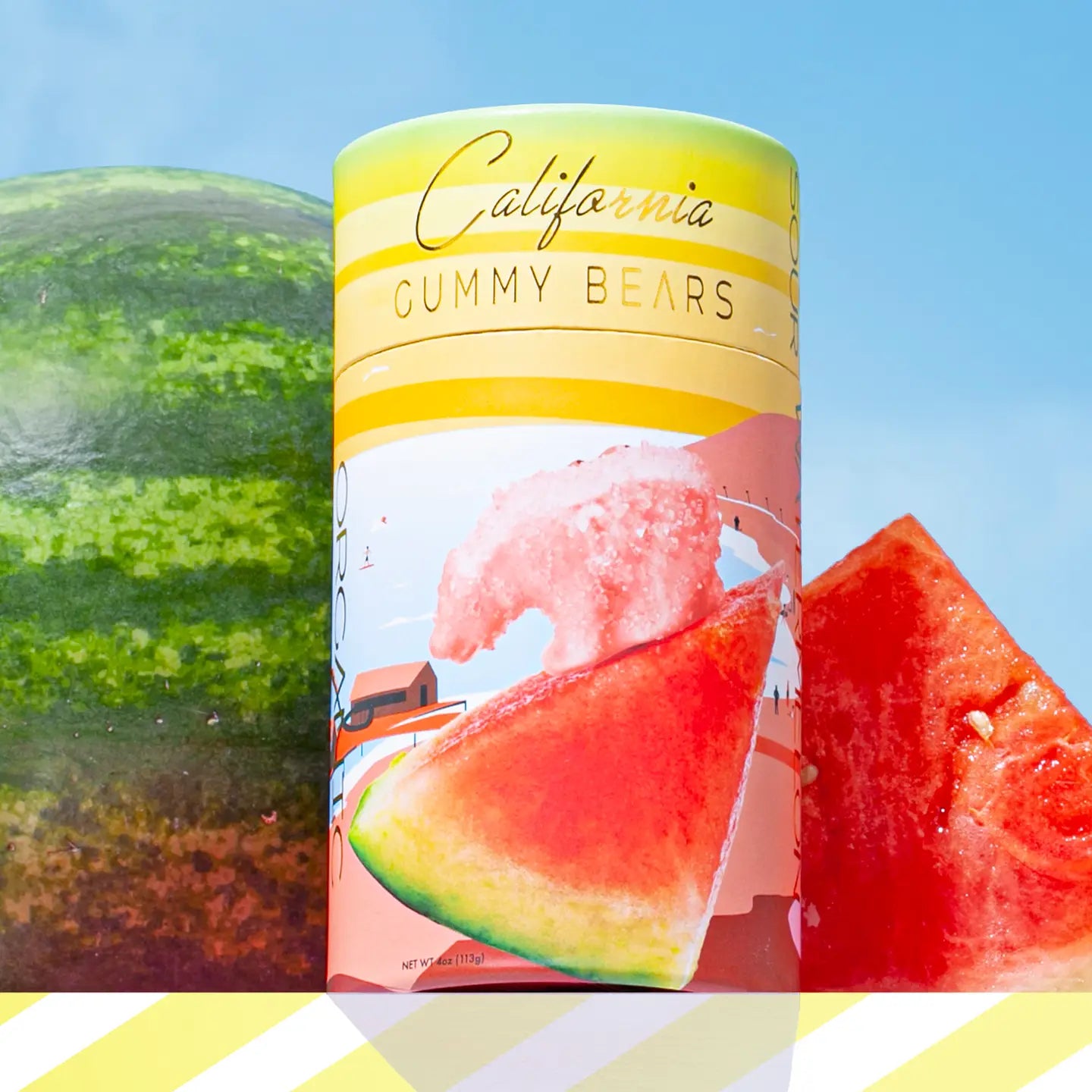 Canister of California Gummy Bears with watermelon slices and a watermelon in the background