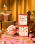 Bath bombs and packaging labeled 'Yuletide Glow' on a festive background with gold and pink decorations.