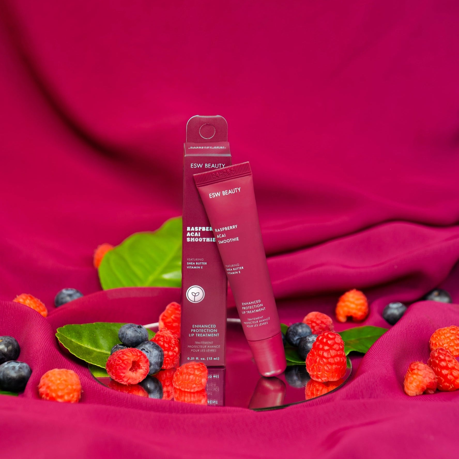 purple lip gloss next to blueberries & raspberries