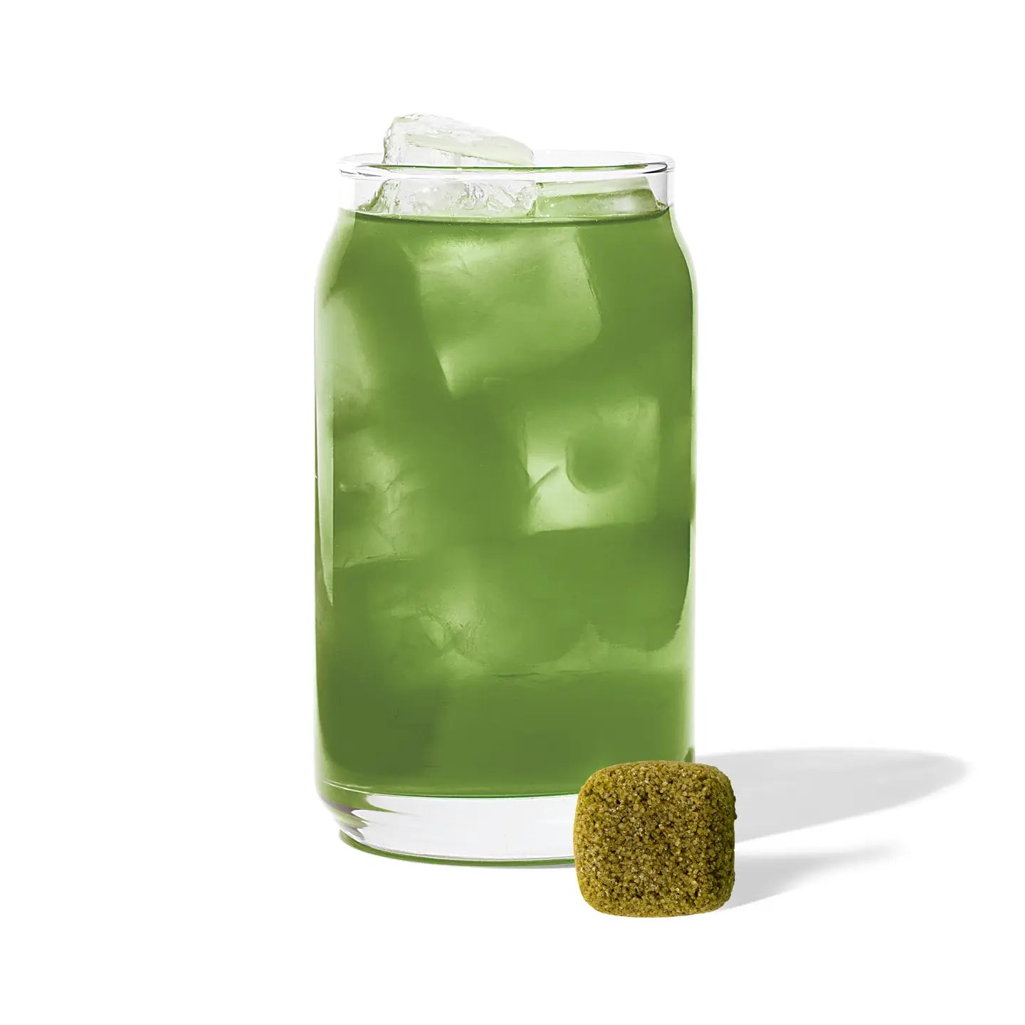 Green drink with ice cubes in a glass on a white background
