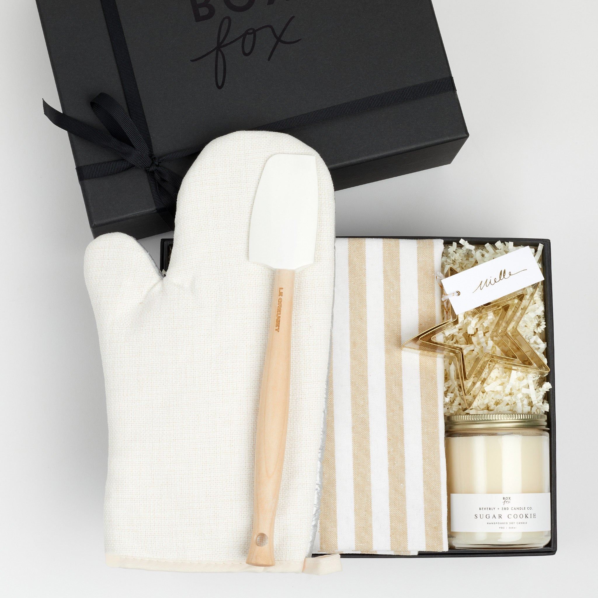 The BAKING box in black, which includes an oven mitt, spatula, striped dish towel, cookie cutters and a sugar cookie candle.