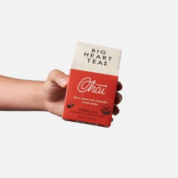 red and white tea package with hand holding it