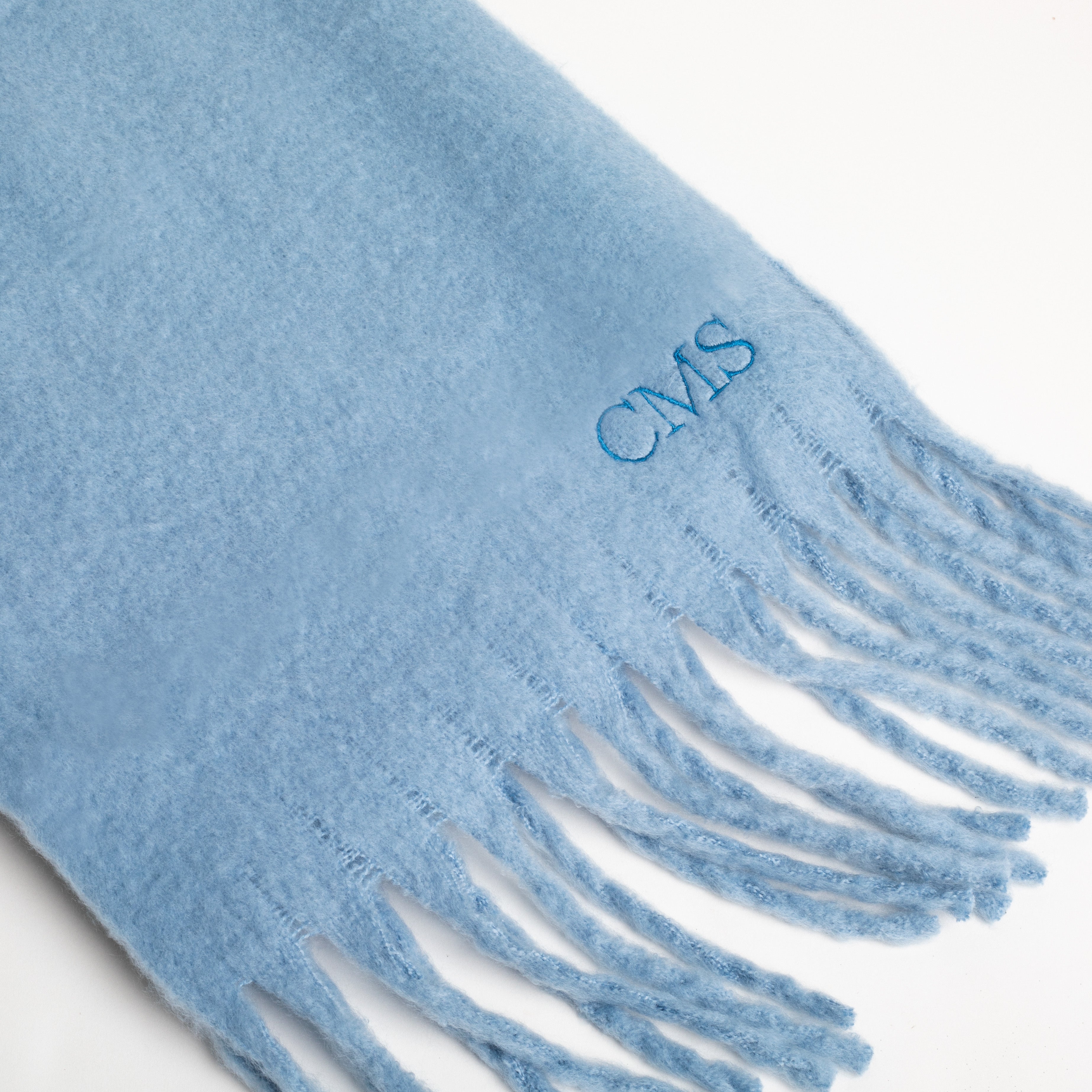 Blue scarf with fringes and 'CMS' embroidery on a white background