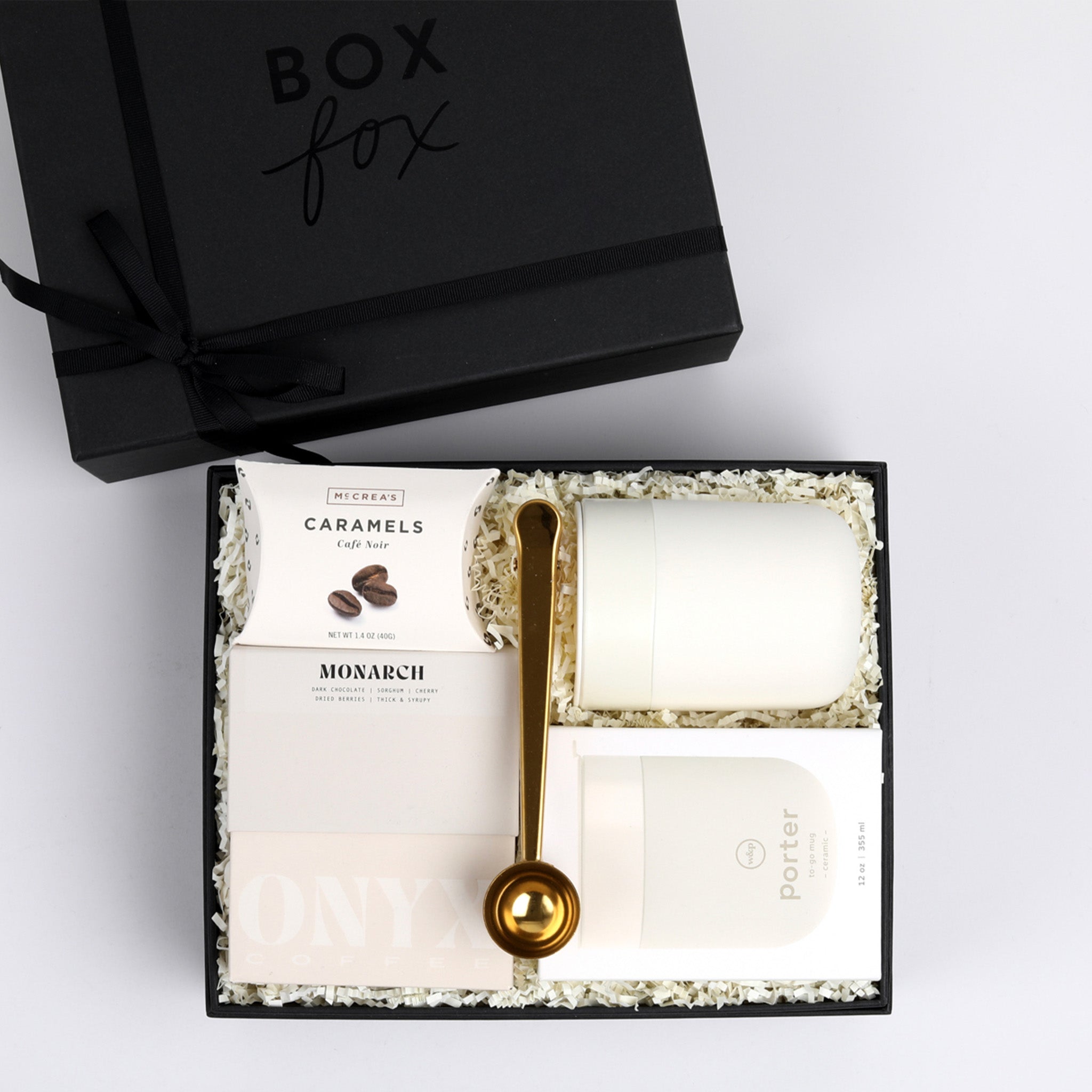 Black Matte BOXFOX gift box packed with gold coffee scoop, coffee caramels, cream mug and box of coffee 