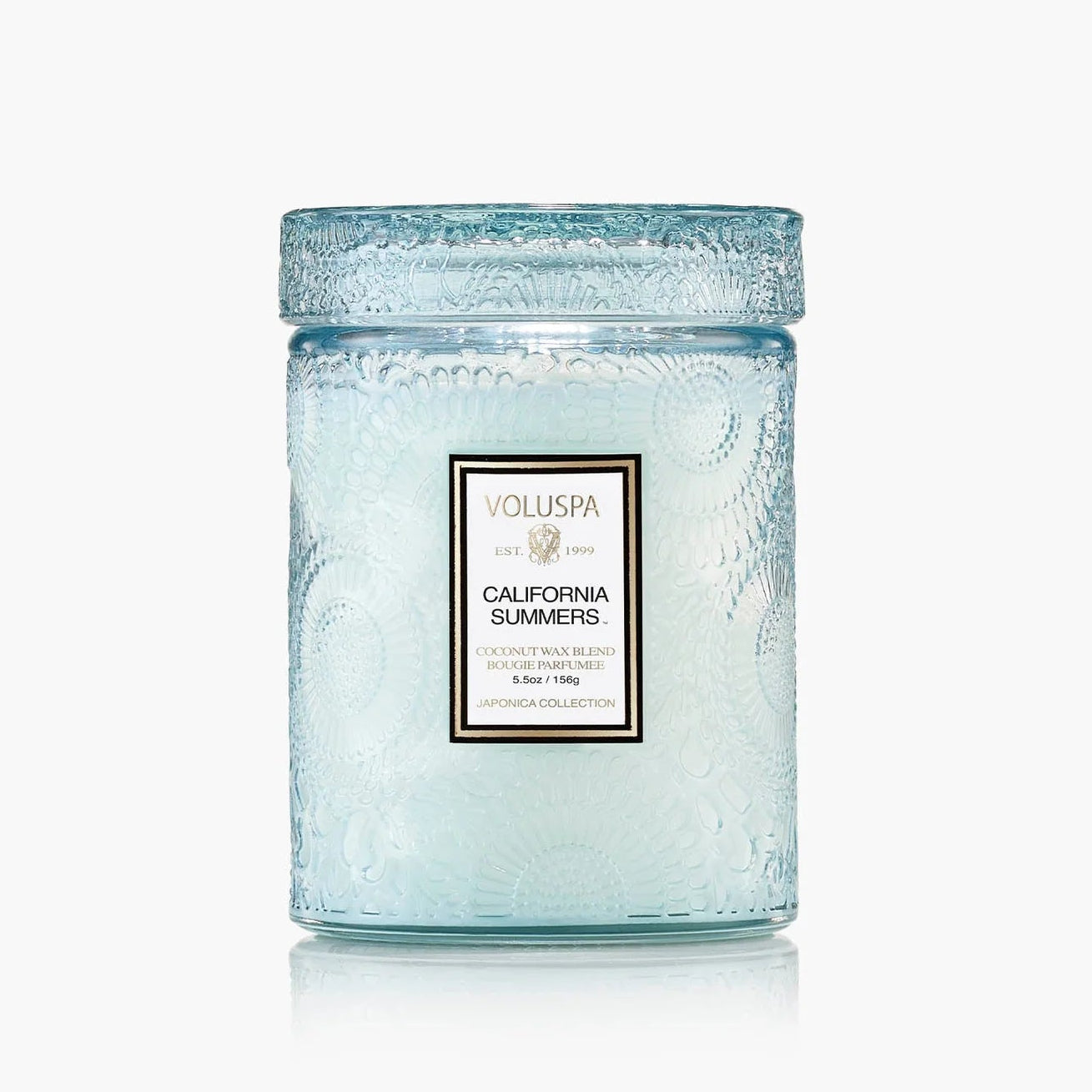 Light blue candle in a glass jar with Voluspa branding on a white background