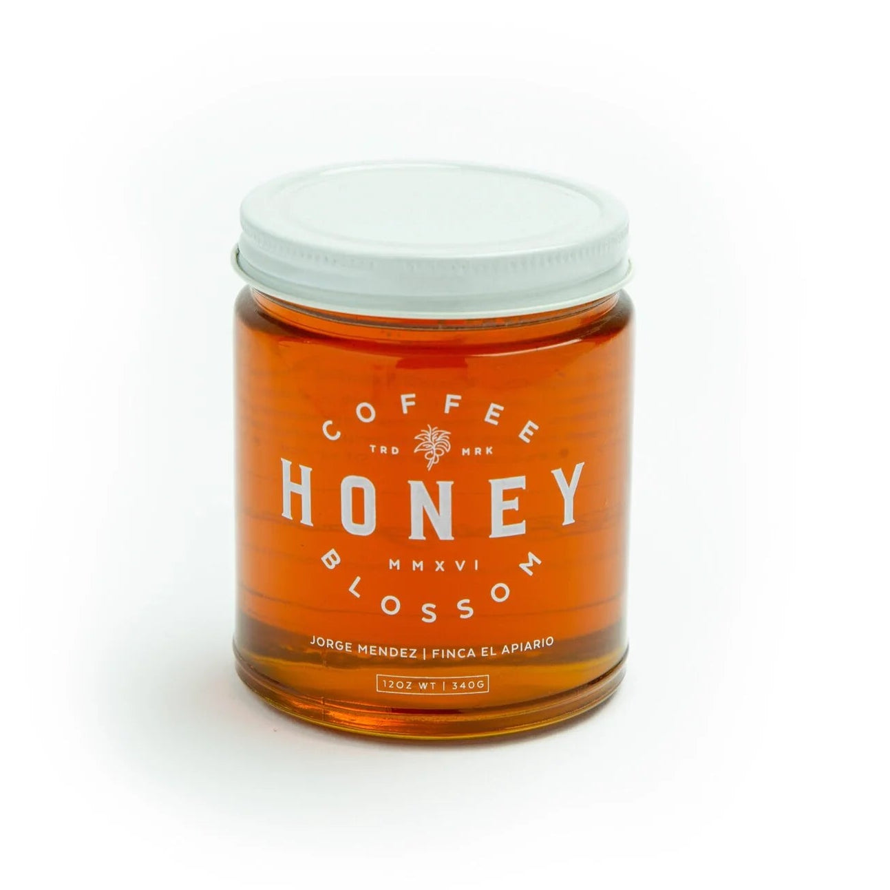 Jar of honey with a white lid on a white background