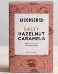 light pastel red box with brown illustrated caramels printed all over it. Box has white rectangle on the front with text listing product name and company