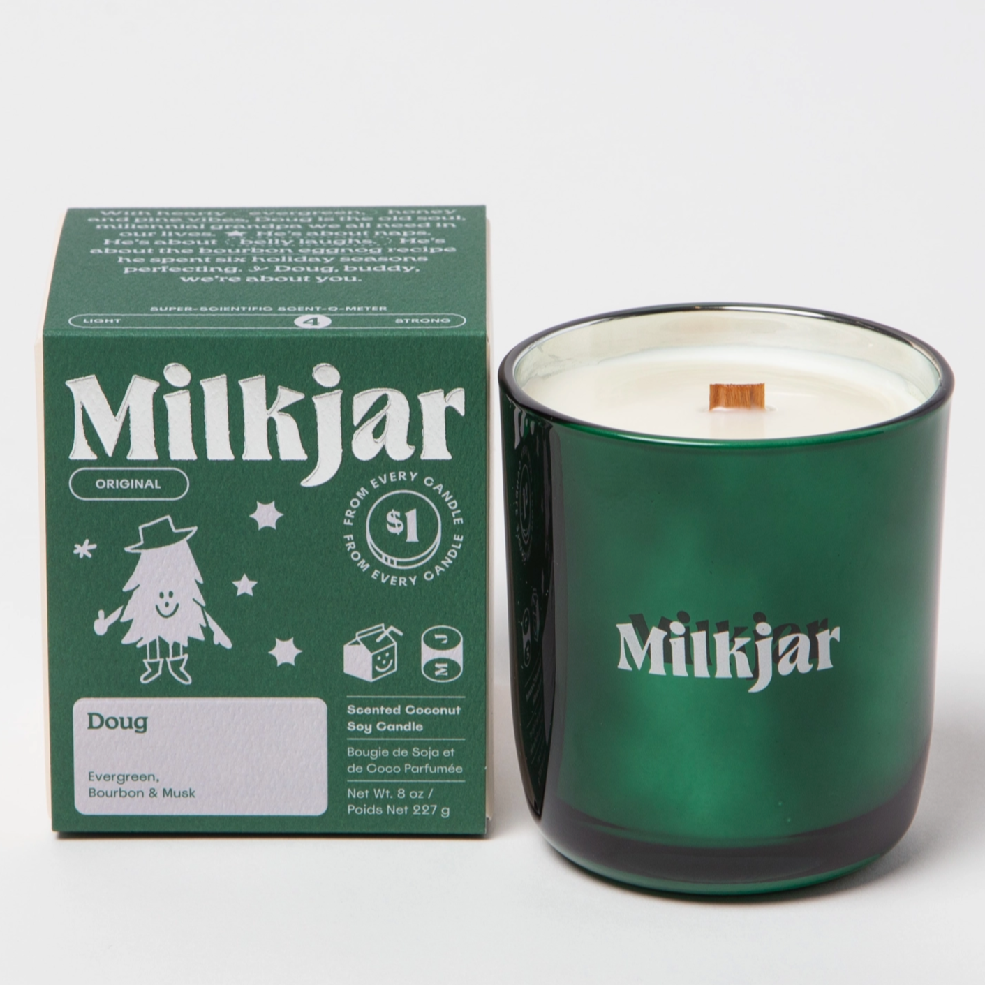 The image shows a green glass candle with a matching green box beside it. The box and candle both display the brand name "Milkjar." The box is labeled with the scent name "Doug," and lists fragrance notes: evergreen, bourbon, and musk. The label mentions that the candle is made of coconut soy wax and that $1 from each candle is donated to charity. The candle has a wooden wick visible at the center.