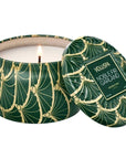 green tin candle lit with gold detail