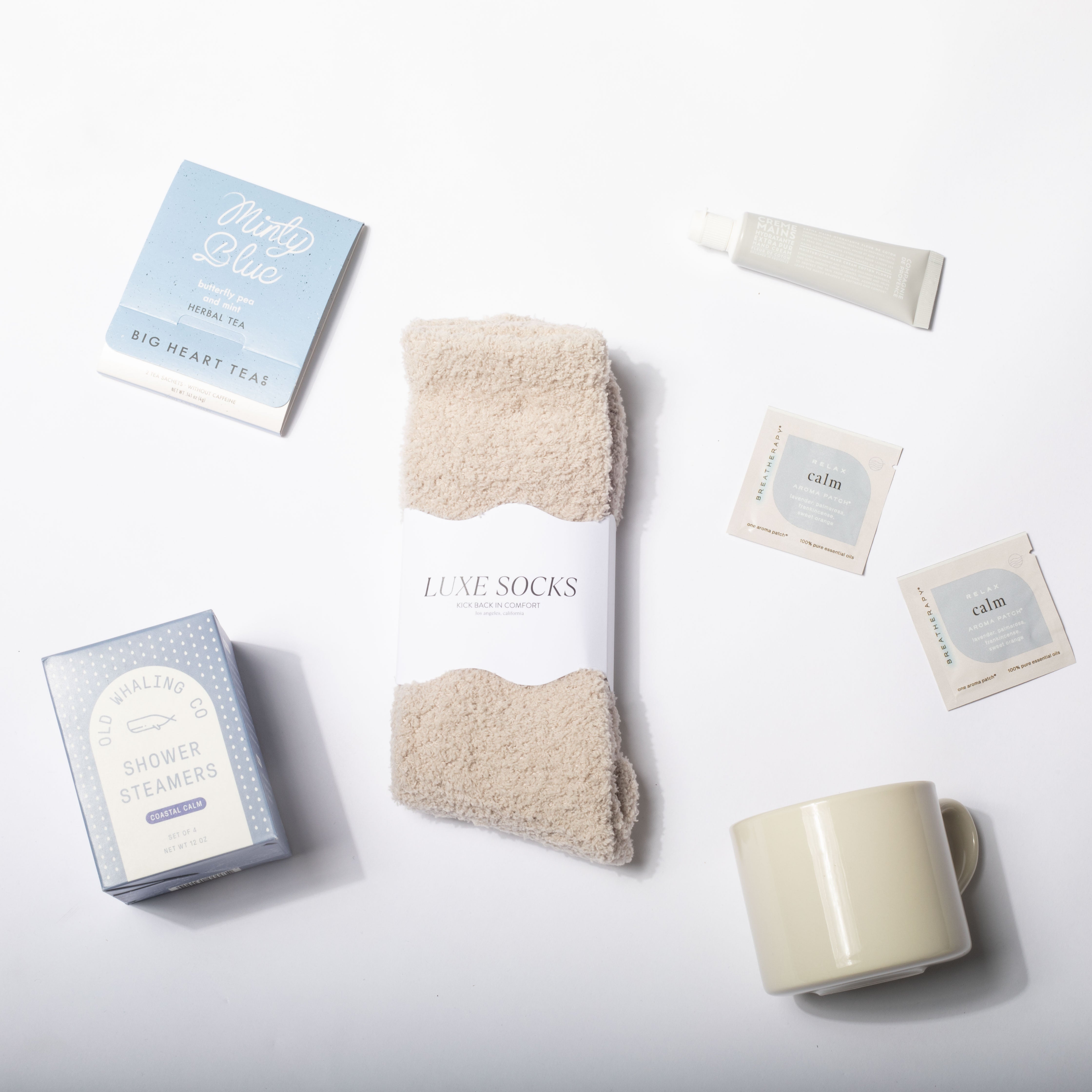 Set of items including a mug, socks, and tea packages on a white background